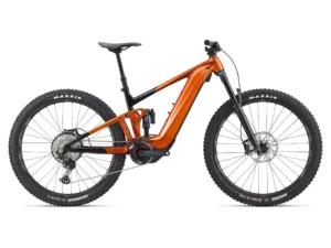 Trance x e+ 1 electric recreational bikes in amberglow color, with maxxis tires on both the front and back and an integrated tubeless wheel system.