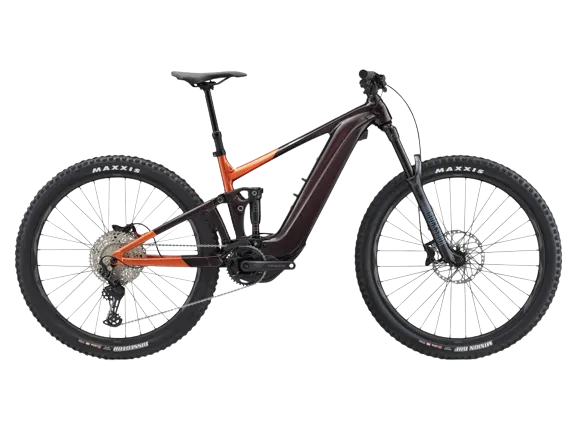 A giant trance x e+ 3 electric bike in cordovan color, with maxxis tires in both the front and back.